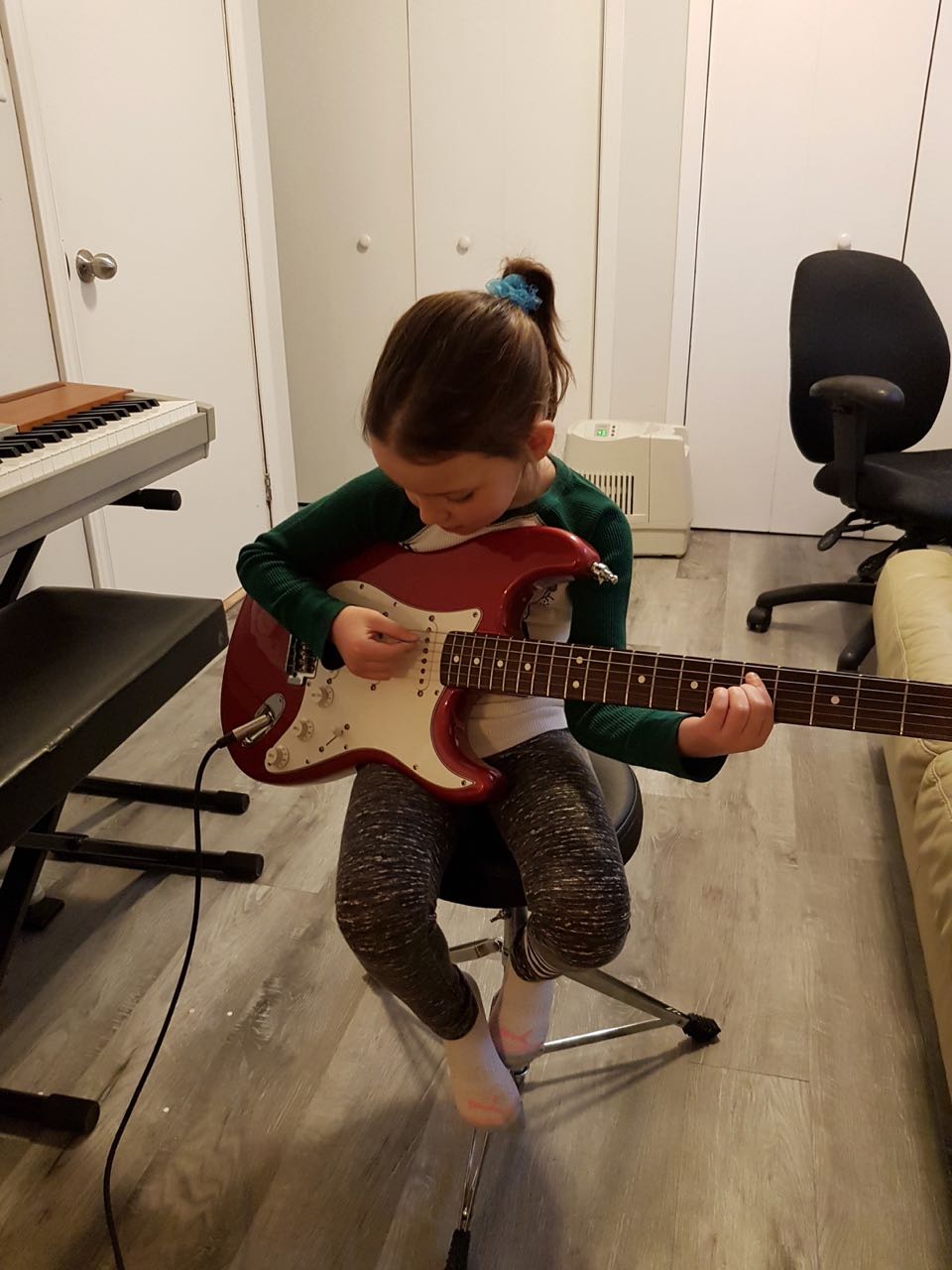 Young girl plays electric guitar on stage in Barrie