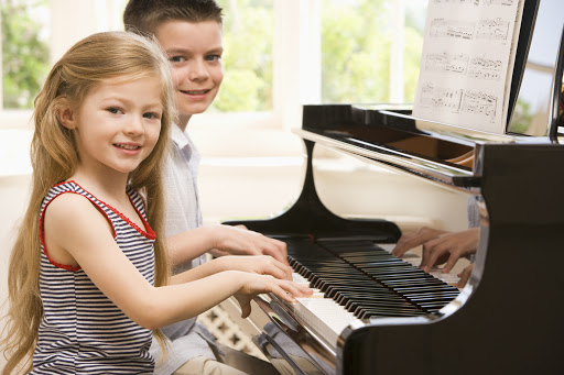 2 young children attend a piano lesson in Barrie